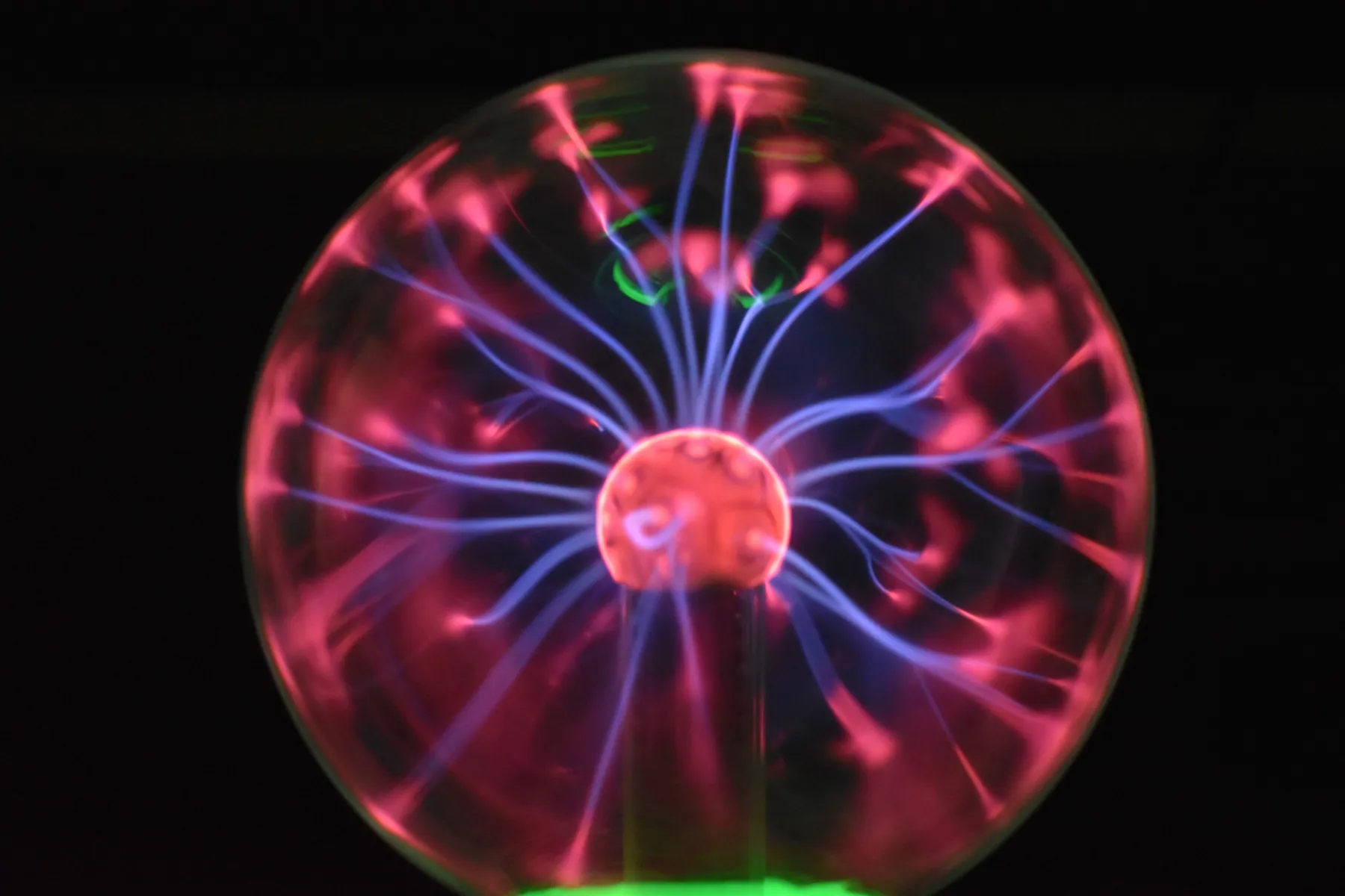 A plasma lamp: filaments of charge, each pulled by the field of all the others. Vlasov's move was to replace the swarm with the field of its own average. Photograph by Gergő, Pexels.