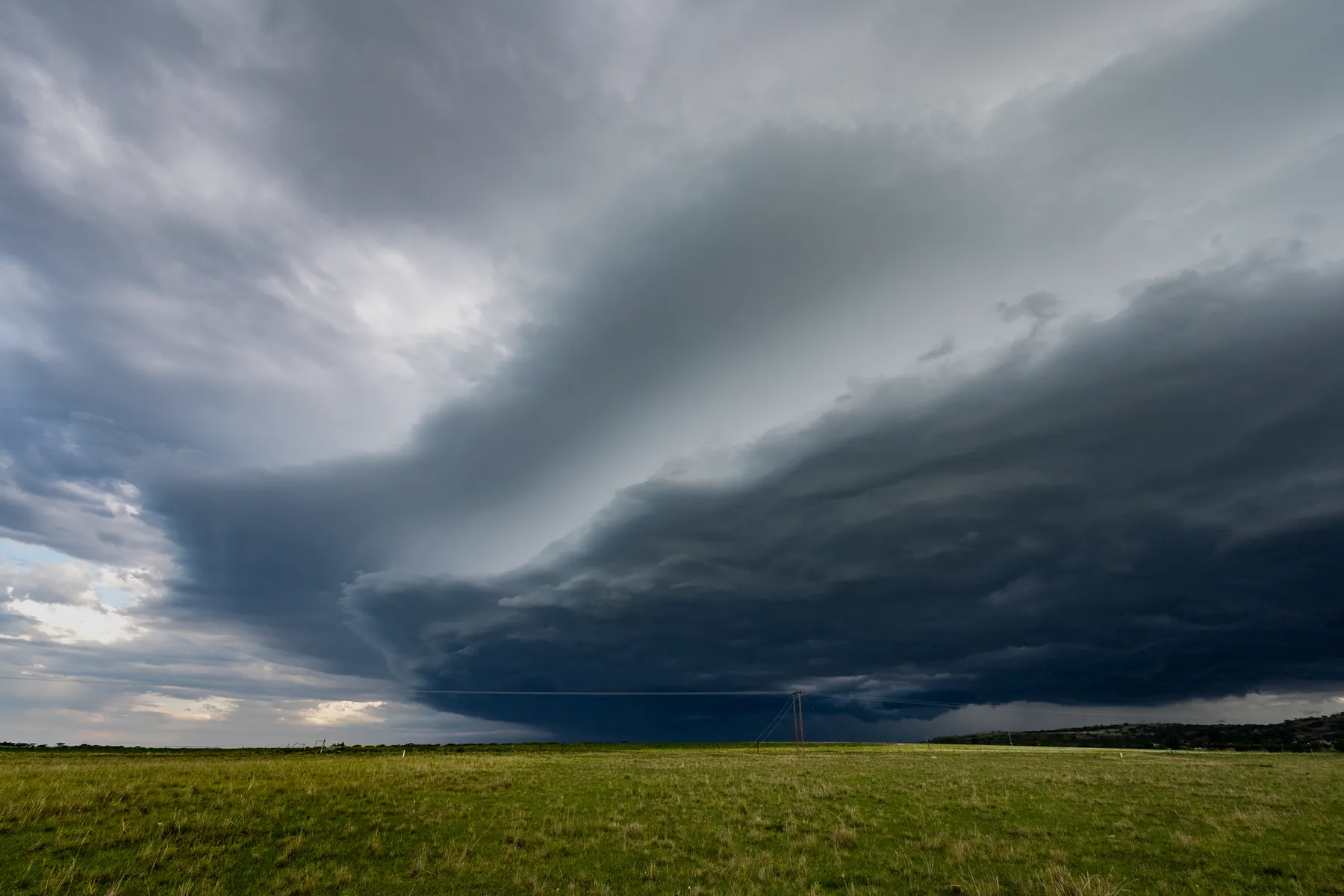 Storm clouds over a green field. Photograph: Ndumiso Mvelase, Pexels.