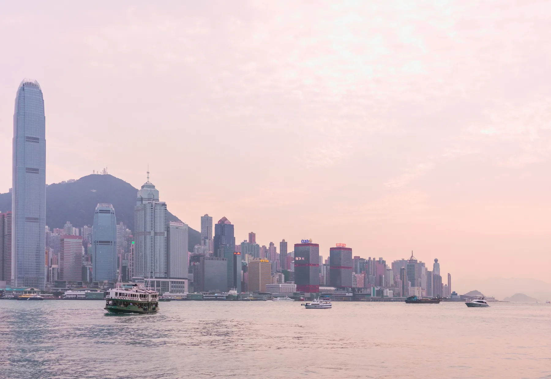 Hong Kong Island across Victoria Harbour at dusk, with a Star Ferry crossing. Photograph by Ana Benet, Pexels.